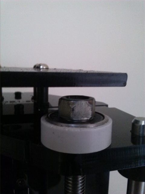 Load support bearings for Z axis rods. Note the nut screwed to the threaded rod supporting the weight through the bearing?