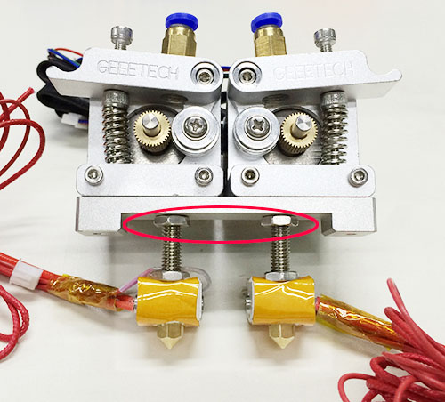 Unscrew the upper nuts, lower down the two hotends to a proper height
